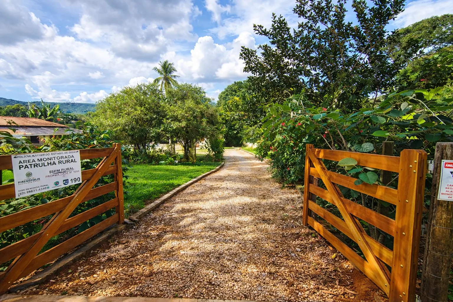 Entrada do chalé cercada por jardim e vegetação da propriedade.